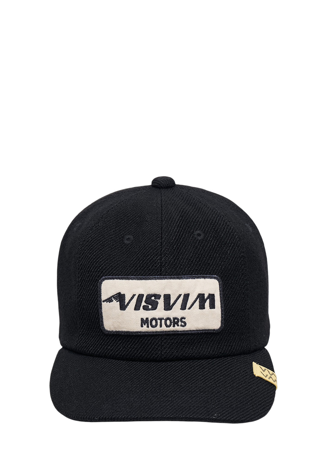 visvim Excelsior II black cap with cream embroidered Visvim Motors patch and yellow woven tag on the brim