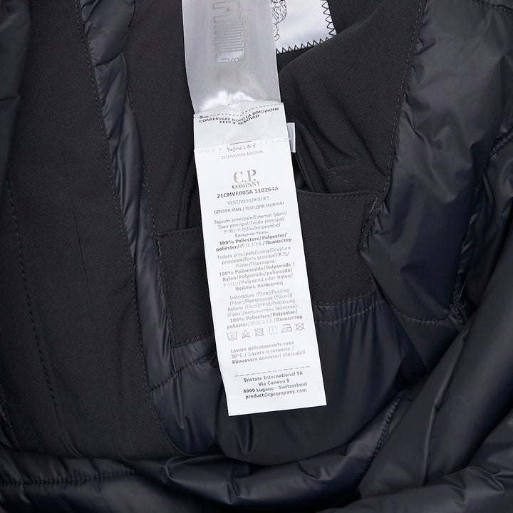 C.P. Company Pro-Tek Primaloft Silver Vest in dark grey, front view, showing stand collar, hidden zip placket, chest zip pockets, lower patch pockets, and NFC badge at the hem