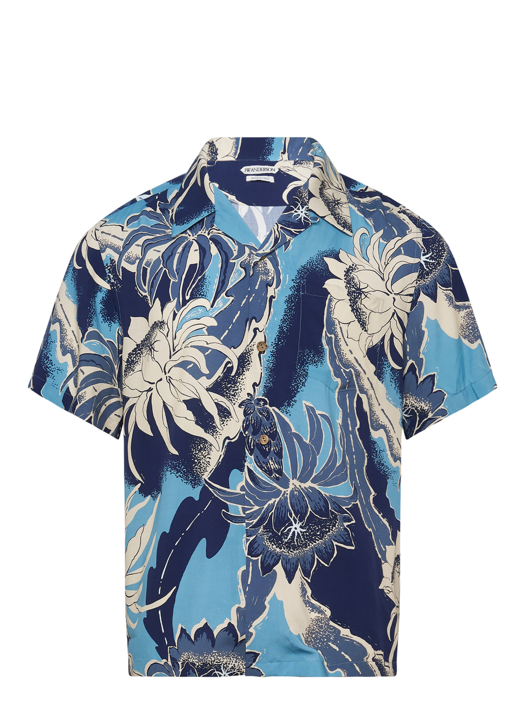 JW Anderson Hawaii Camp Collar Short Sleeve Shirt in a large-scale tropical floral print featuring navy, sky blue, and cream tones, with tortoiseshell buttons and a chest patch pocket