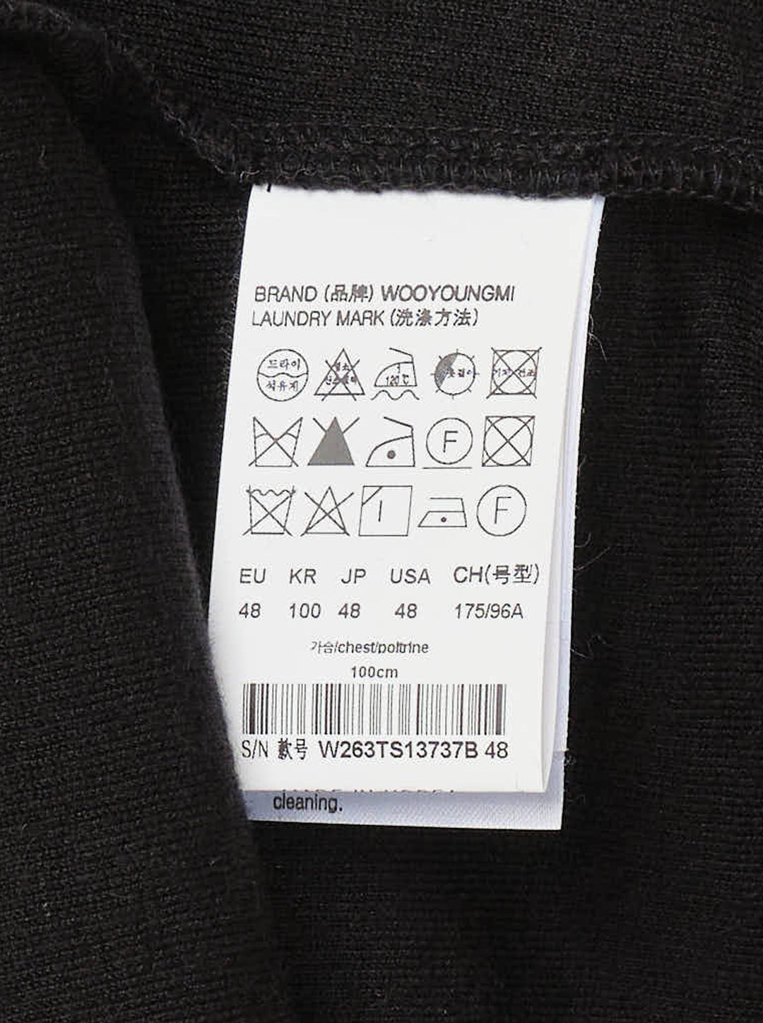 Wooyoungmi Oversized Textured Polo in black, featuring an open-placket collar, boxy short-sleeve silhouette, chest patch pocket with tonal WM monogram badge, and side hem vents - view 3
