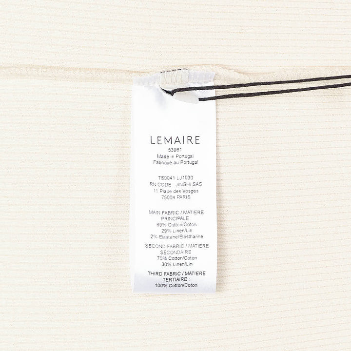 Lemaire long sleeve henley tee in off-white ribbed cotton with a three-button placket and ribbed cuffs, displayed flat on a white background