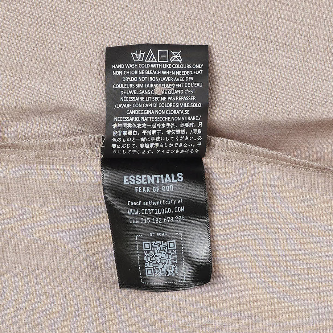 Fear of God Essentials short sleeve button up shirt in black, featuring a boxy oversized silhouette, point collar, and tonal button placket, displayed flat on a white background