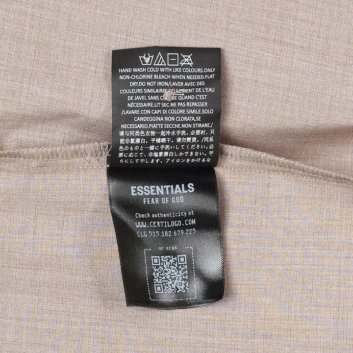 Fear of God Essentials short sleeve button up shirt in black, featuring a boxy oversized silhouette, point collar, and tonal button placket, displayed flat on a white background