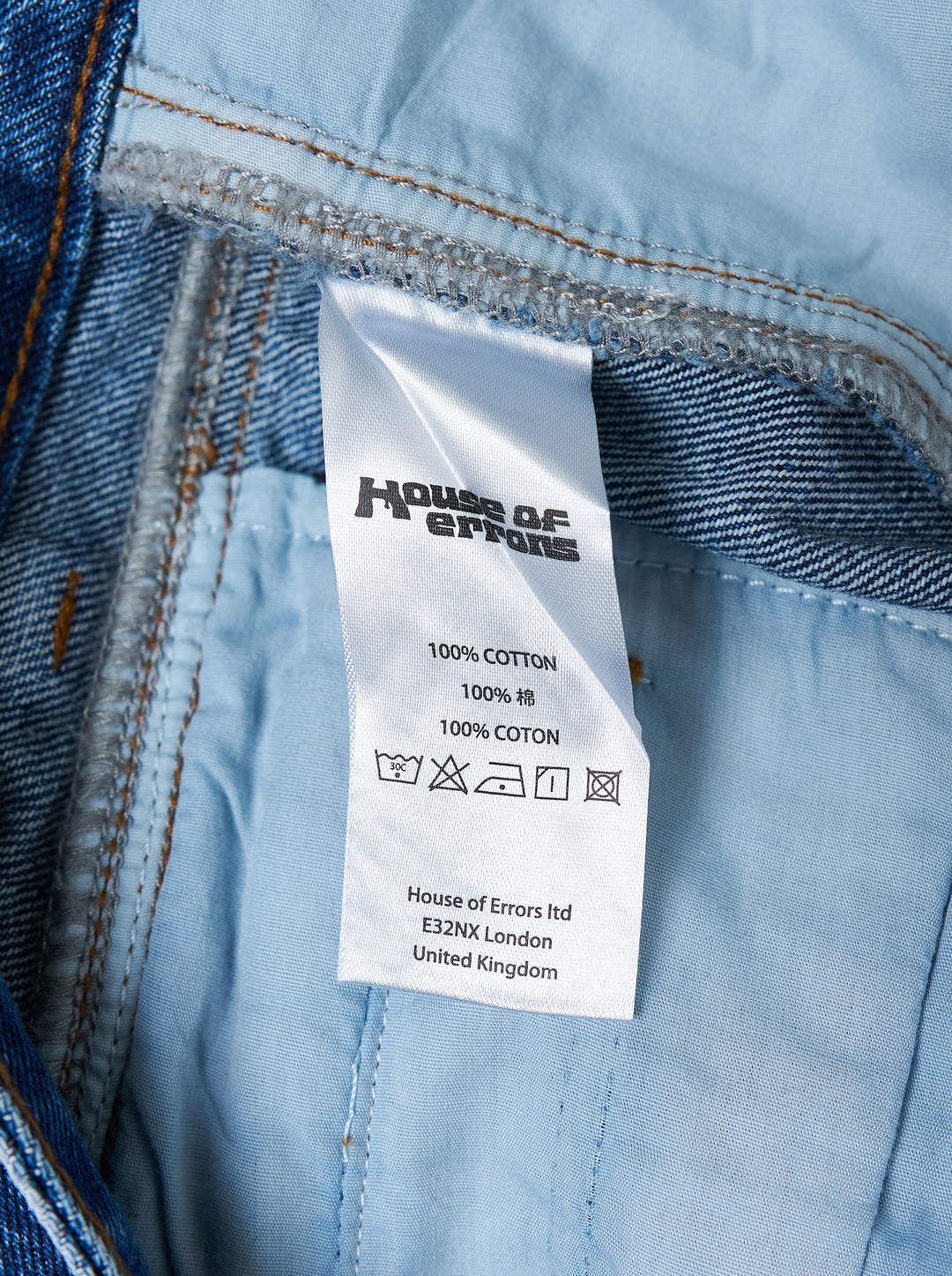 House of Errors Crown Jeans in mid-wash blue denim with whiskered fading, wide-leg cut and gold-tone engraved button, shown flat from the front - view 5