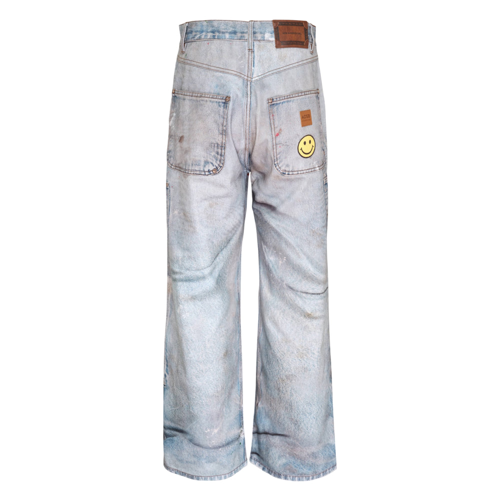 Andersson Bell distressed trompe-l'œil carpenter jeans in light blue heavily washed denim with ripped knees, paint splatter, and utility patch pockets