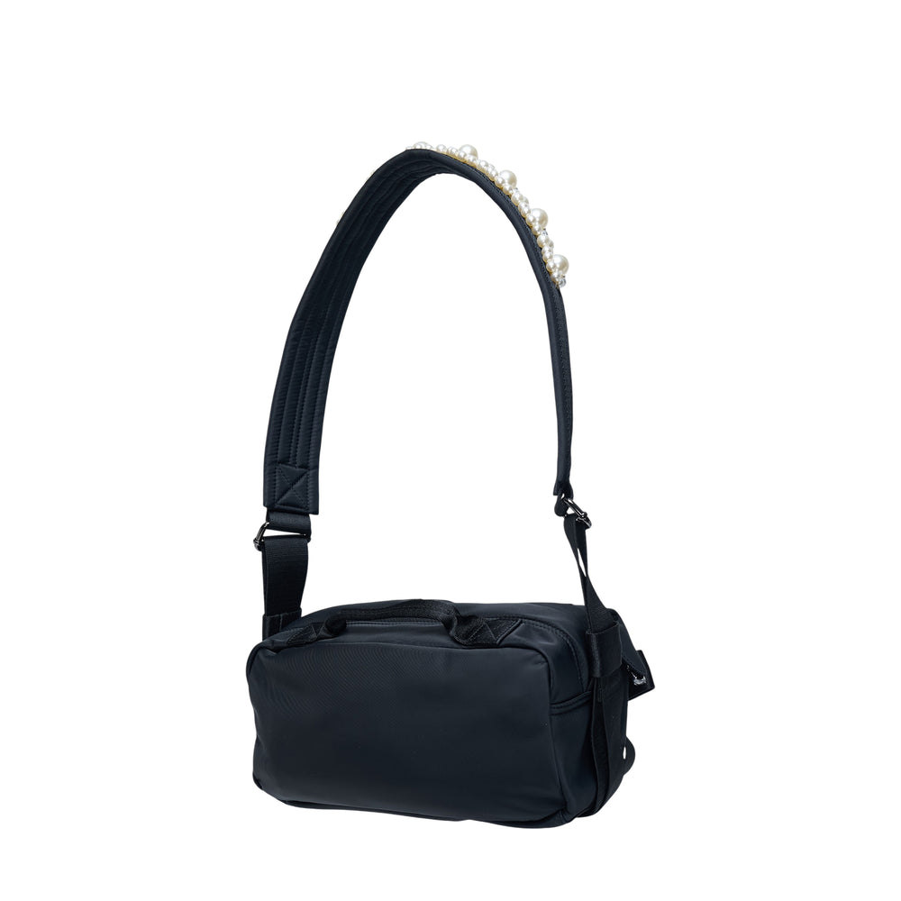 Simone Rocha Classic Bow Crossbody Bag in black nylon with pearl-embellished padded shoulder strap, oversized woven bow detail, and trailing webbing straps, shot on a white background