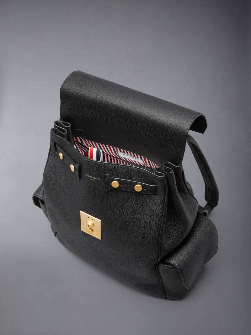 Thom Browne Bolton backpack in black soft pebble leather with brass-tone lock closure, flap side pockets, and red, white, and blue tab detail - view 3