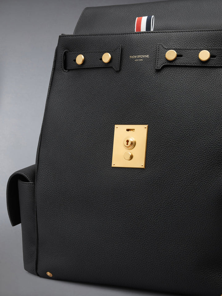 Thom Browne Bolton backpack in black soft pebble leather with brass-tone lock closure, flap side pockets, and red, white, and blue tab detail - view 4