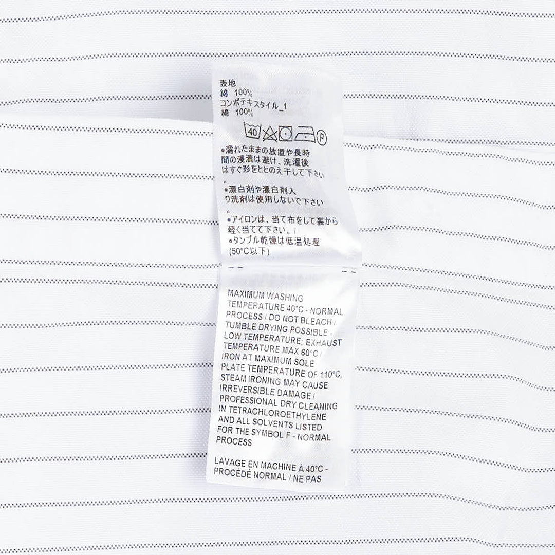 Thom Browne Straight Fit Long Sleeve Shirt in light blue pinstripe with contrast stripe sleeve panels, chest patch pocket, and woven branding label at the hem