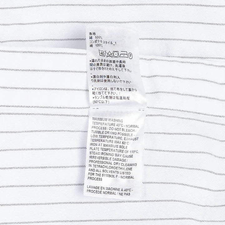 Thom Browne Straight Fit Long Sleeve Shirt in light blue pinstripe with contrast stripe sleeve panels, chest patch pocket, and woven branding label at the hem