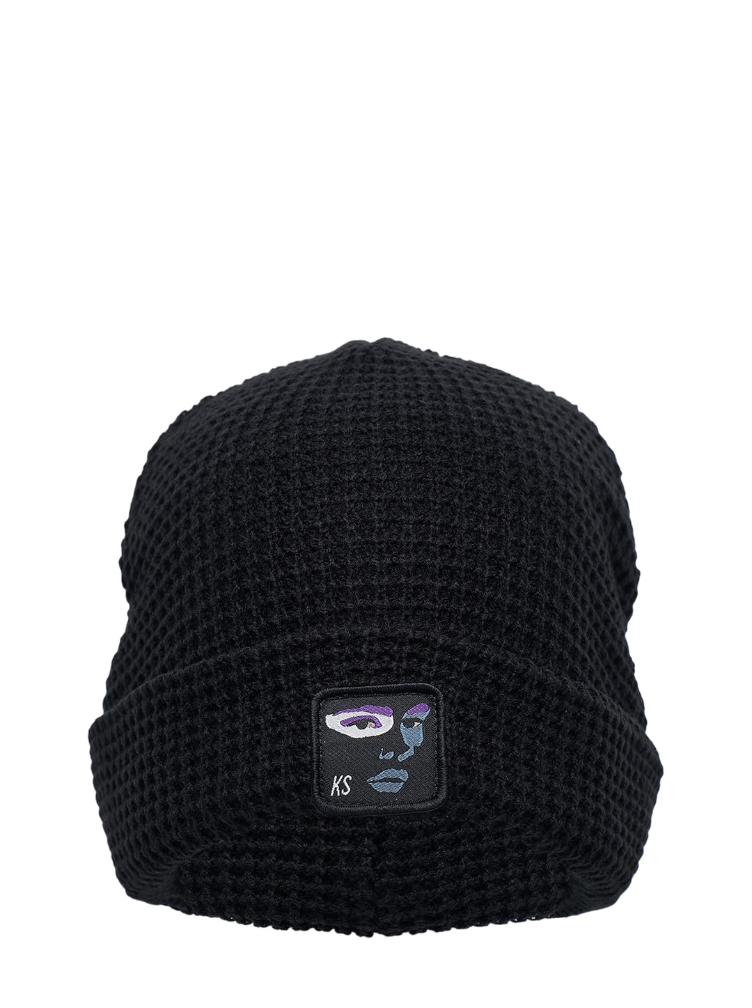 Black waffle-knit cuffed beanie with an embroidered abstract face patch and KS initials on the front