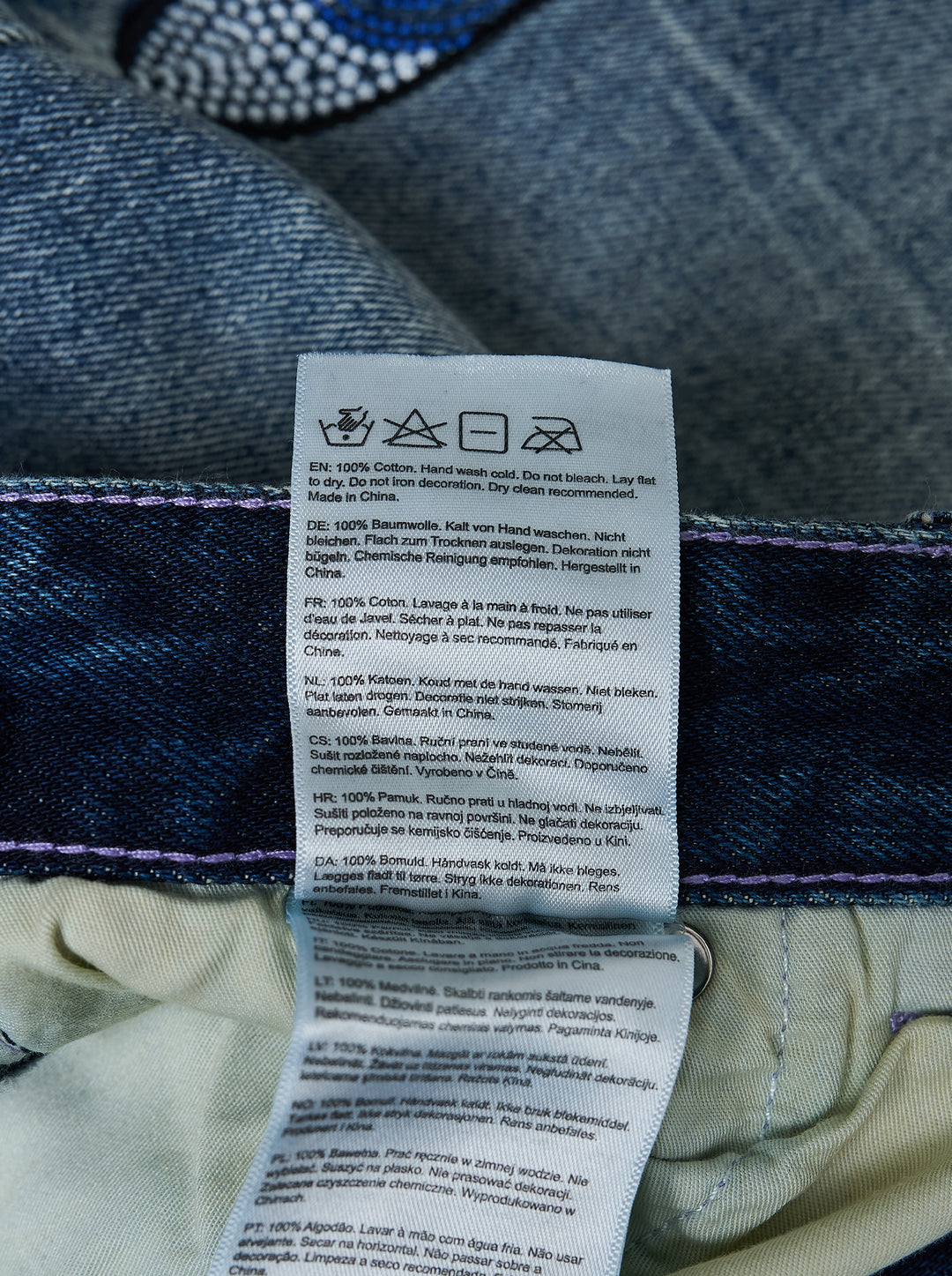 KidSuper Studios Gemstone Eye Embroidery Jeans in faded indigo denim with beaded eye embroidery along both outer legs, shown from the front - view 5