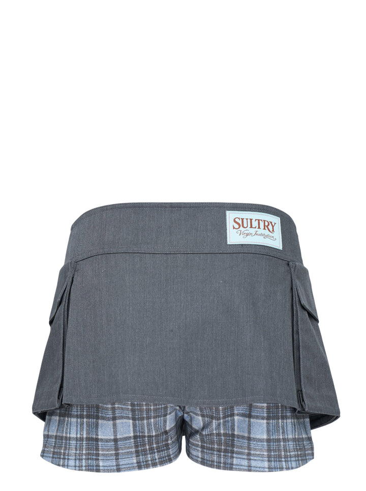 Sultry Virgin Utility Cargo Skort in grey suiting fabric, featuring a crossover wrap waistband with snap buttons, layered pleated panels, cargo pocket detailing, and a plaid underlay at the hem - view 2