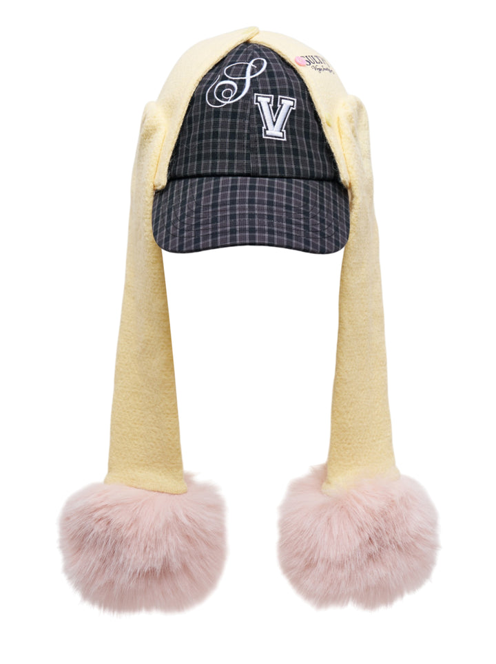 Sultry Virgin Alumni Cardigan Cap in dark plaid with cream fleece drop-ear panels and oversized blush faux-fur pom-poms, featuring embroidered SV lettering on the front