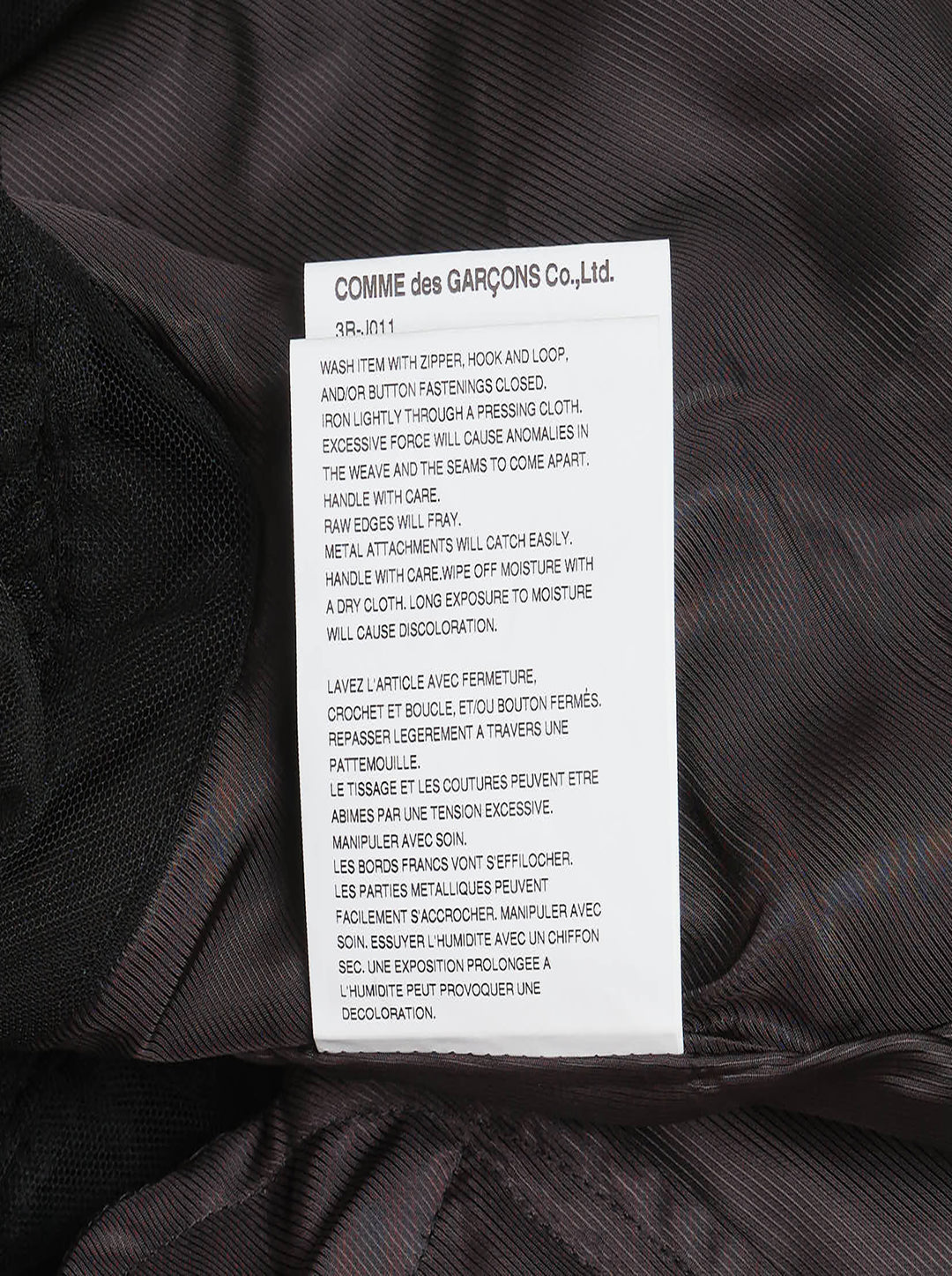 Noir Kei Ninomiya black elasticated waistband mini skirt with ruched woven panels, adjustable drawstring toggles, and layered tiered tulle hem, photographed flat on white background - view 4