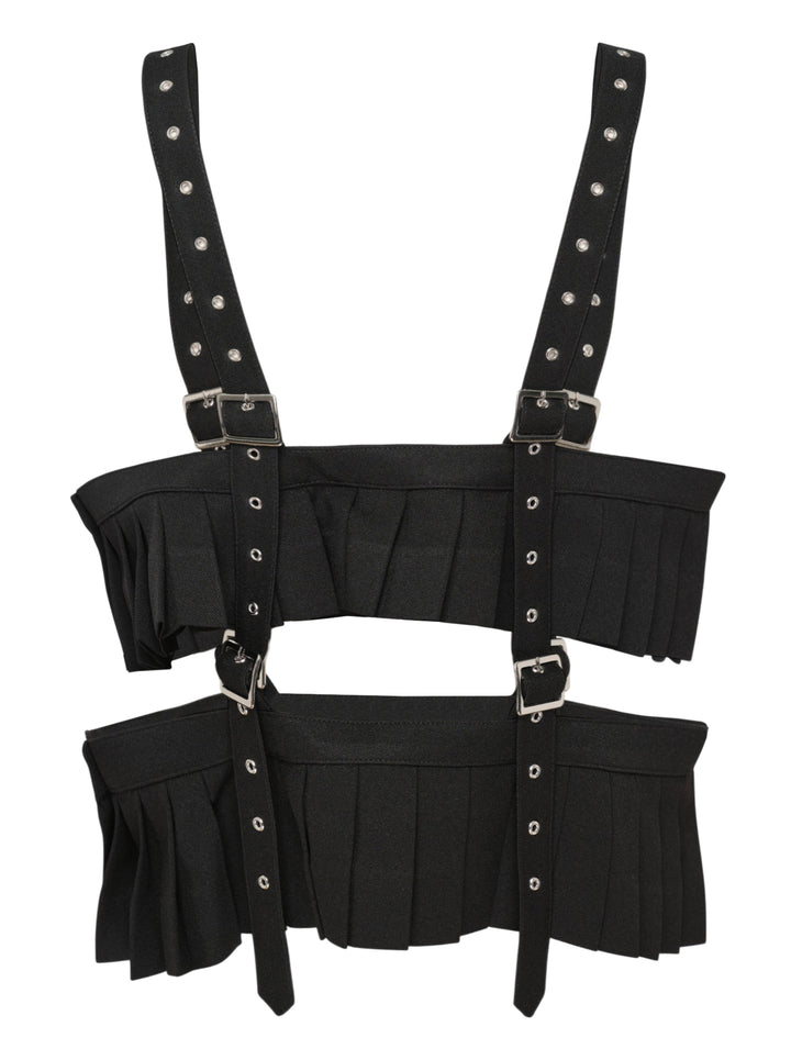 Noir Kei Ninomiya black polyester gabardine harness vest with knife-pleated panels, silver buckles, and studded shoulder straps on a white background - view 2