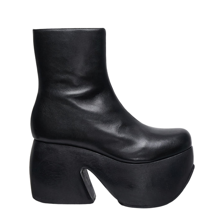 Comme des Garçons x John Fluevog black leather platform ankle boot with sculptural carved heel block and rounded square toe, side profile view
