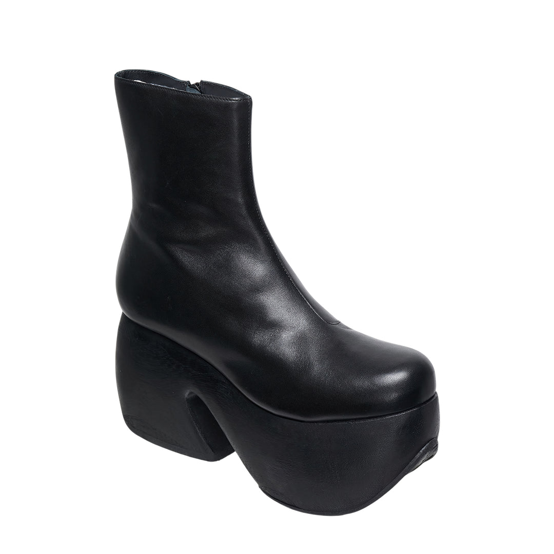 Comme des Garçons x John Fluevog black leather platform ankle boot with sculptural carved heel block and rounded square toe, side profile view