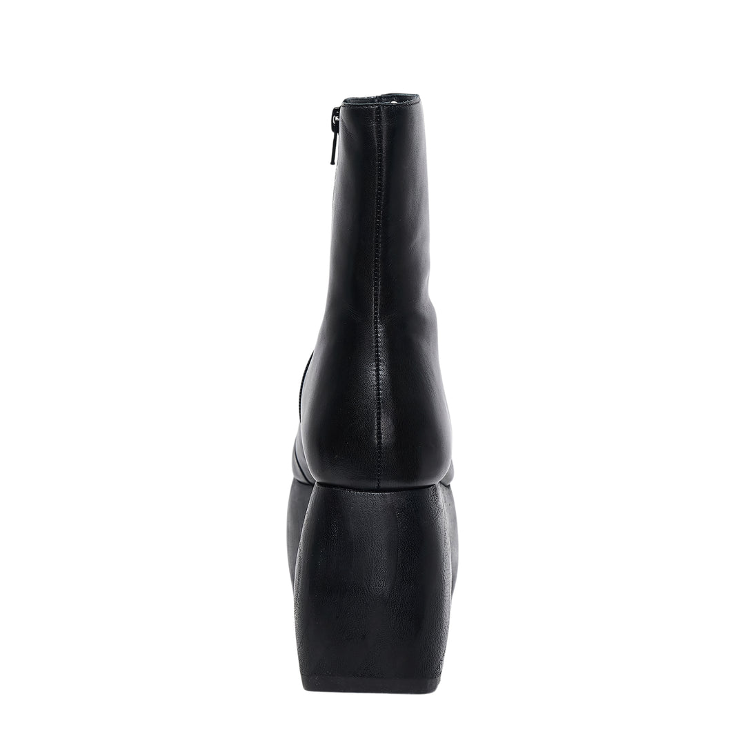 Comme des Garçons x John Fluevog black leather platform ankle boot with sculptural carved heel block and rounded square toe, side profile view