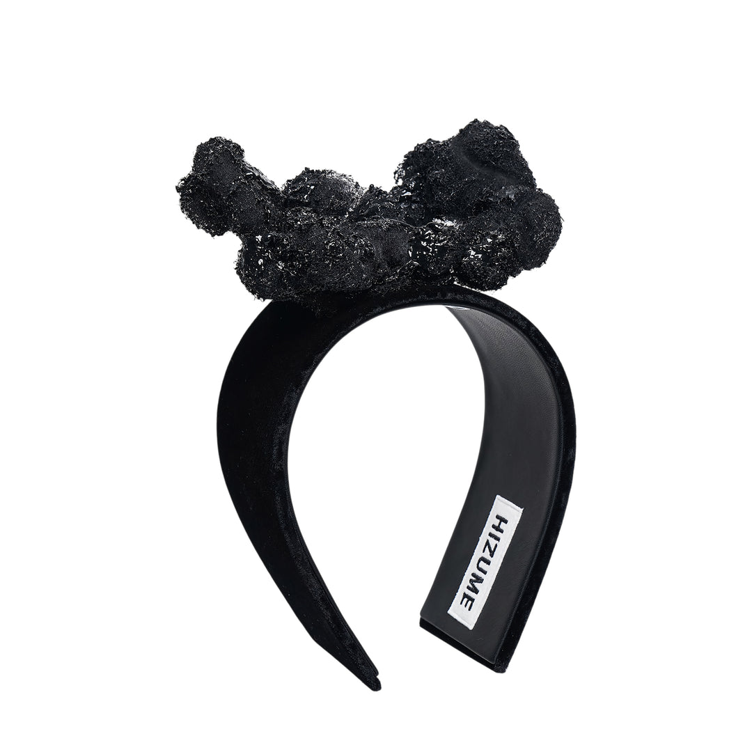 Comme des Garçons x HIZUME black velvet headband with an oversized sculptural beaded and sequined bow embellishment, shown on a white background