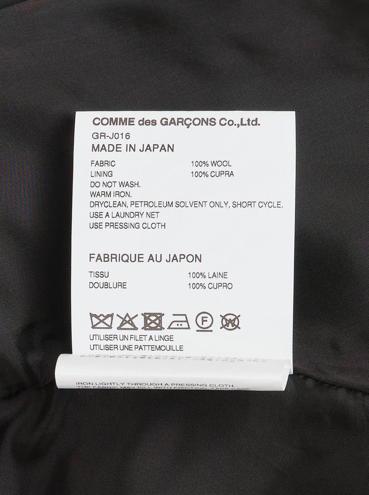 Comme des Garçons black sculptural asymmetric blazer with deconstructed layered lapels, mother-of-pearl buttons, and asymmetric hem revealing satin lining, photographed flat on white background - view 3
