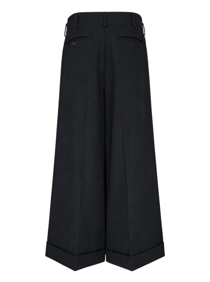 Comme des Garçons black wide leg pleated trousers with high waist, double front pleats, and deep turned-up cuffs, photographed flat on a white background - view 2