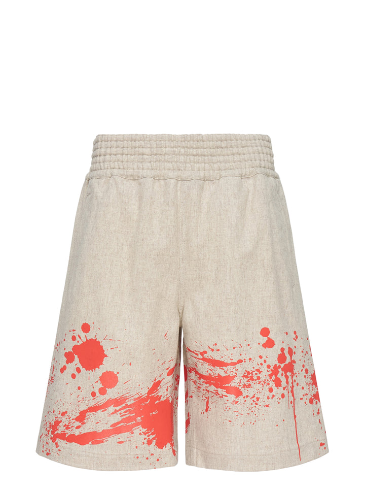 Comme des Garçons Shirt oatmeal wool shorts with red paint splash print along the hem and a ribbed elasticated waistband