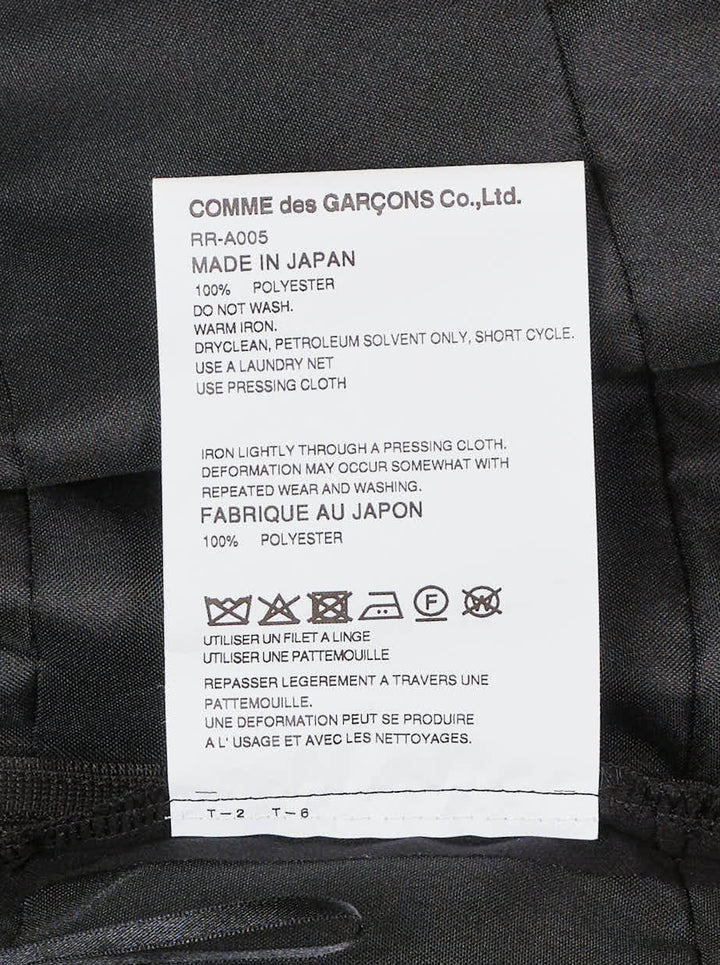 Comme des Garçons Comme des Garçons black crossover pinafore with cascading tiered ruffle skirt and structured waistband, shown from the back against a white background - view 3