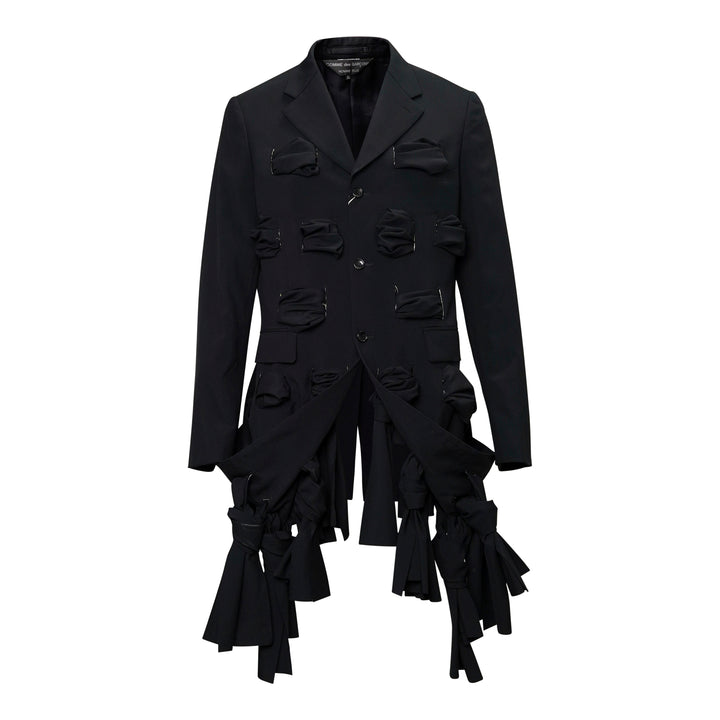 Comme des Garçons Homme Plus black tropical wool single-breasted jacket with gathered fabric loop appliqués across the body and cascading deconstructed strip detailing at the hem, front view on white background