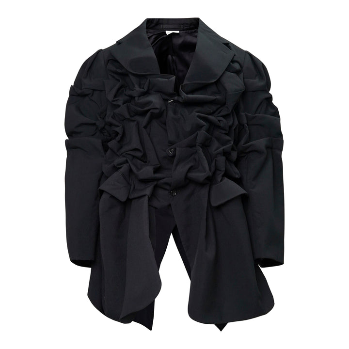 Comme des Garçons Homme Plus black wool tropical jacket with dramatic sculptural ruffles cascading across the chest and shoulders, long sleeves, and a notched lapel collar, displayed on a white background