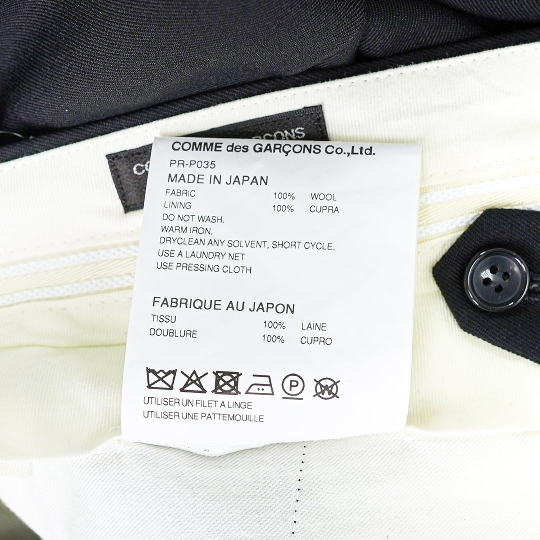 Comme des Garçons Homme Plus wool gabardine double-pleat high-rise tapered trousers in dark charcoal, flat lay on white background - view 3