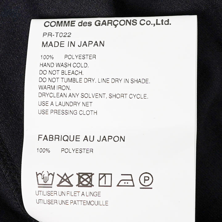 Comme des Garçons Homme Plus black long-sleeve polyester jersey tee with sculptural curved overlay bib panel and open split hem, displayed flat on white background - view 3