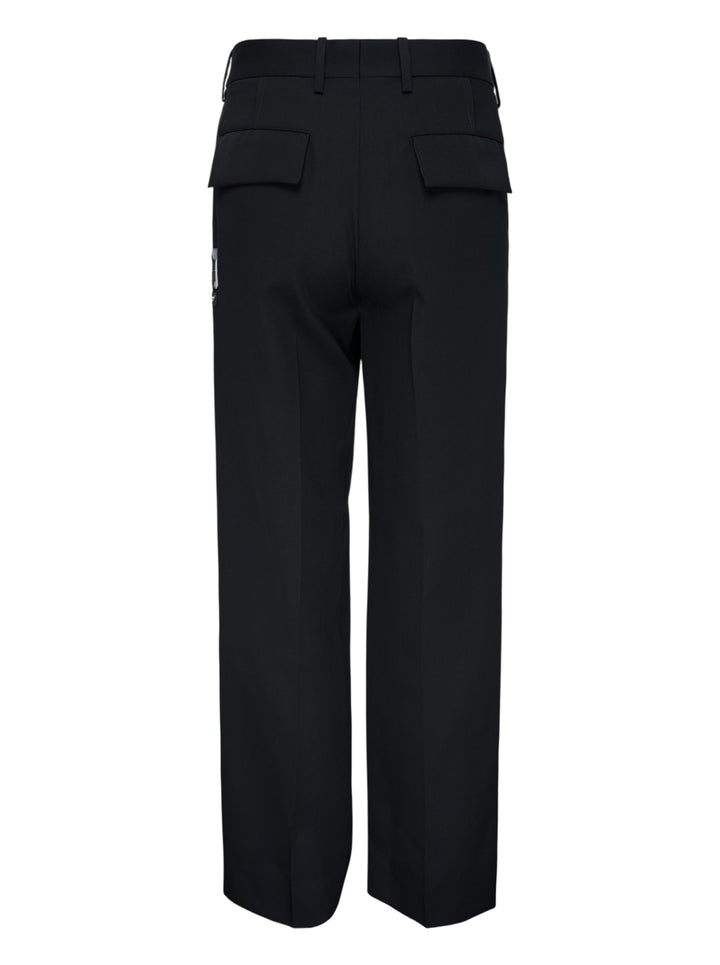 Undercover Cindy Sherman Patch Trousers in black, front view showing straight-leg tailored cut with pressed crease and patch detail - view 2