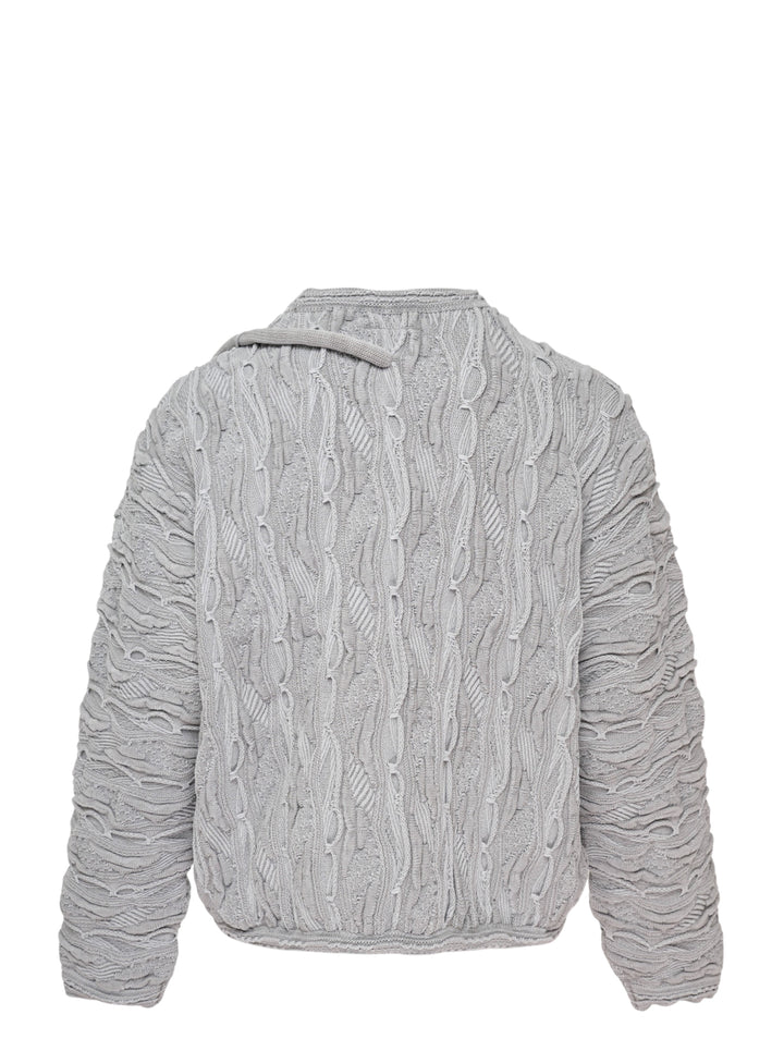 doublet Air Yarn Regulator Knit Pullover in grey, featuring distressed cable-knit texture across the body and sleeves with an attached scuba regulator hardware detail on the sleeve, crew neckline, shot flat on a white background - view 2