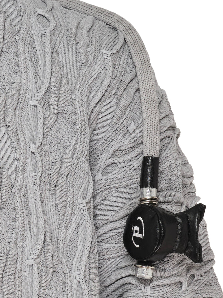 doublet Air Yarn Regulator Knit Pullover in grey, featuring distressed cable-knit texture across the body and sleeves with an attached scuba regulator hardware detail on the sleeve, crew neckline, shot flat on a white background - view 3