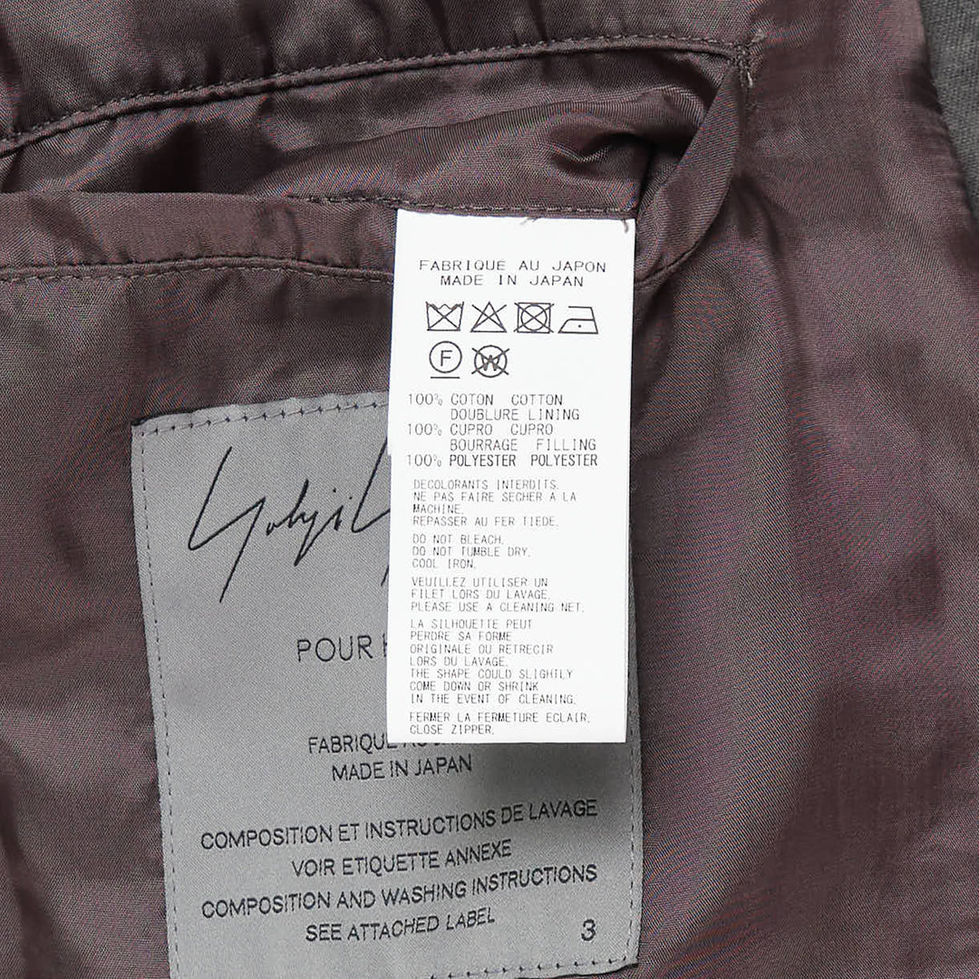 Yohji Yamamoto Military Field Coat in washed charcoal cotton canvas, displayed flat, showing open lapels with mauve lining, zip chest pockets, epaulette shoulders, and large flap cargo pockets - view 3