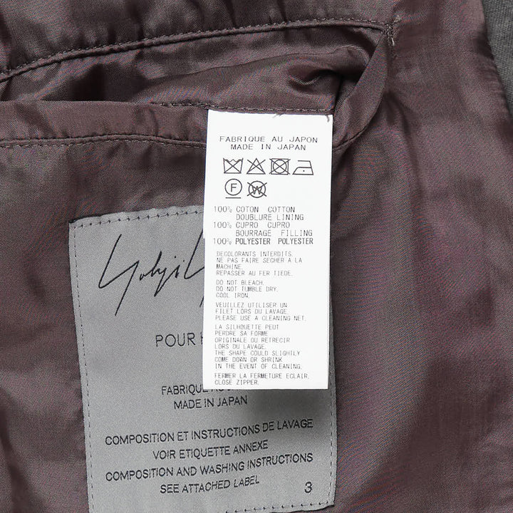 Yohji Yamamoto Military Field Coat in washed charcoal cotton canvas, displayed flat, showing open lapels with mauve lining, zip chest pockets, epaulette shoulders, and large flap cargo pockets - view 3