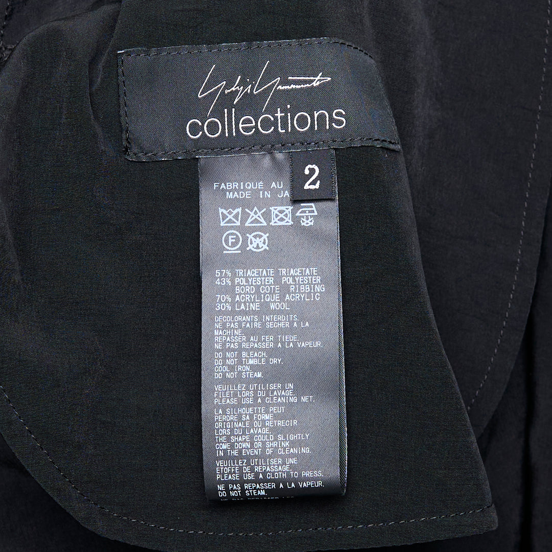 Yohji Yamamoto black hooded raglan sleeve midi dress with button-front fastening and fluid A-line silhouette, photographed flat on white background