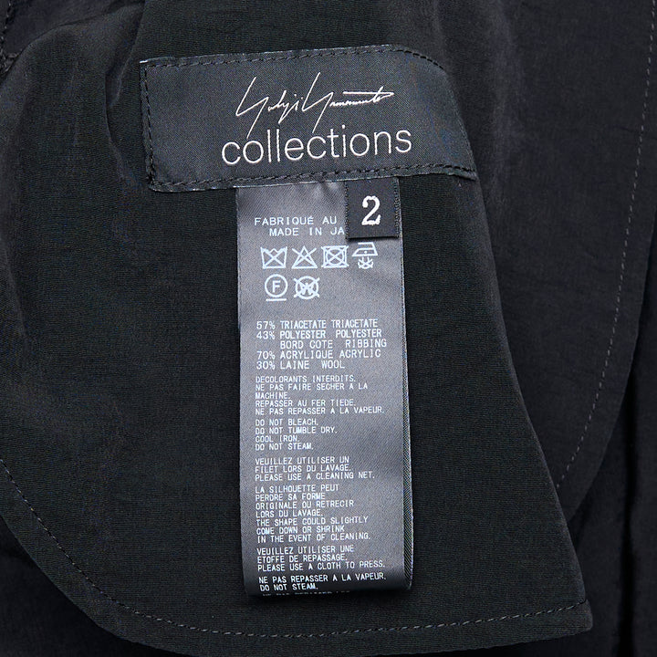 Yohji Yamamoto black hooded raglan sleeve midi dress with button-front fastening and fluid A-line silhouette, photographed flat on white background