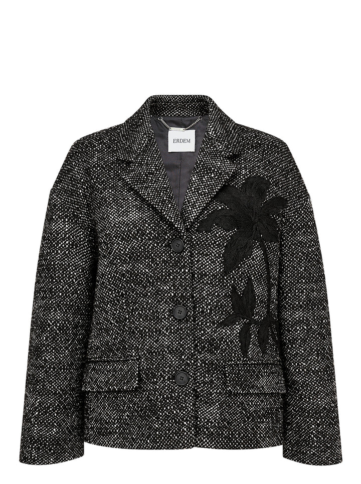 Erdem cropped jacket in salt-and-pepper wool tweed with notched lapels, three black buttons, flap pockets and a black botanical appliqué on the front