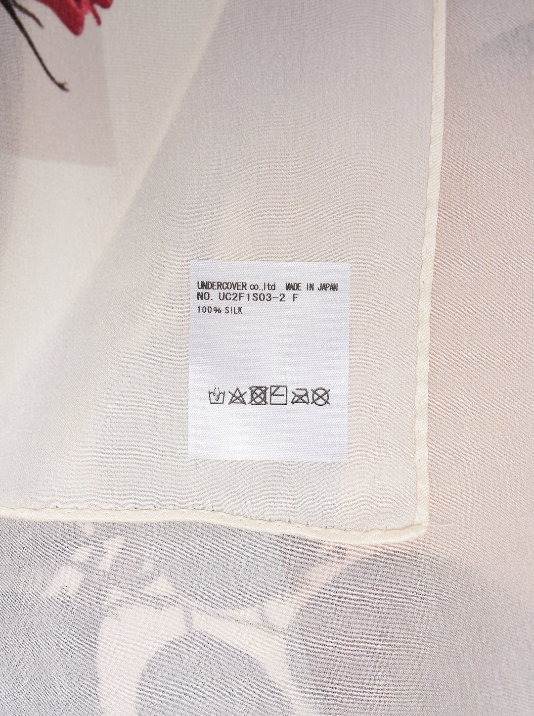 Undercover square scarf printed with five clusters of red roses, buds, and green leaves on an ivory ground with a pale border - view 2