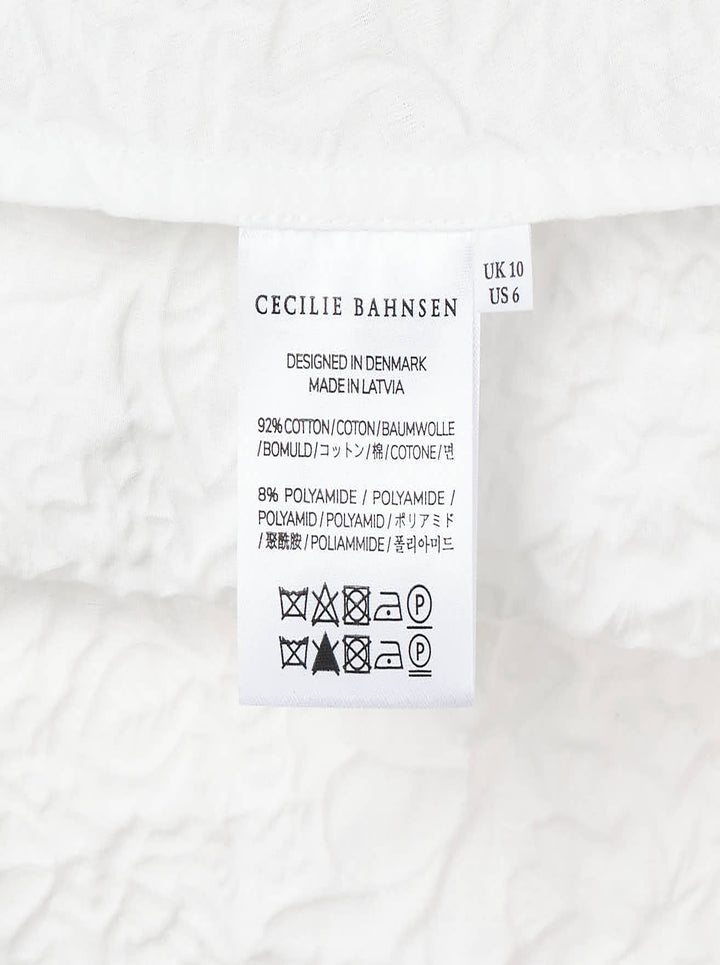 Cecilie Bahnsen Floratini Matelassé sleeveless top in white, shown from the back, featuring an all-over raised floral quilted pattern, gathered bow details along both side seams, and a concealed back zip closure - view 5