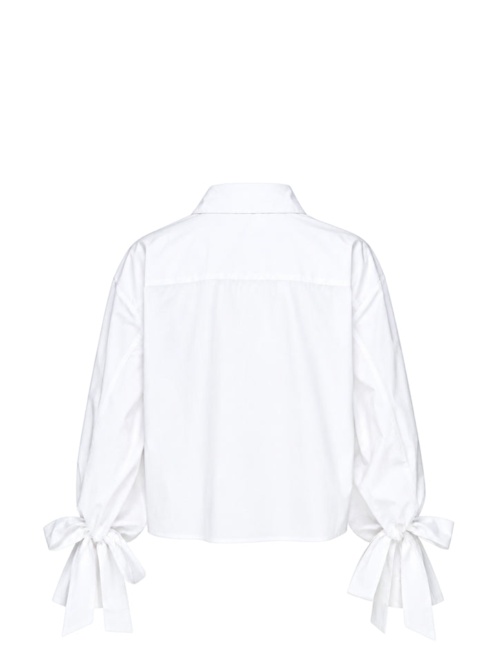 Cecilie Bahnsen Frina cropped white cotton shirt with bow-tied flared cuffs, tonal floral embroidered chest pocket, and button-through front placket, displayed flat on a white background - view 2