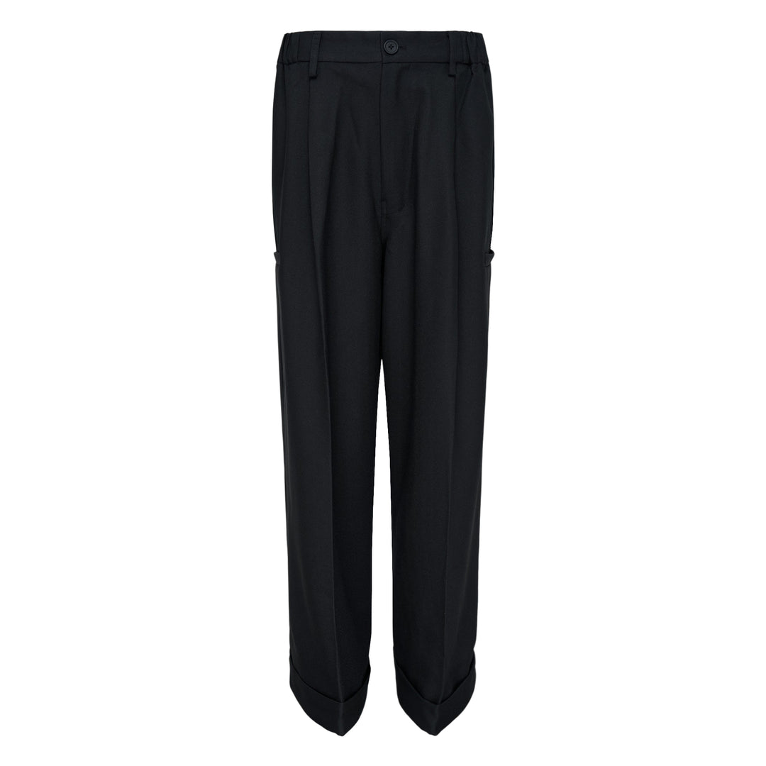 Melitta Baumeister Pointy Tailored Pants in black, featuring wide-leg silhouette, front pleats, thigh-level welt pocket, and sculptural pointed cuffed hem