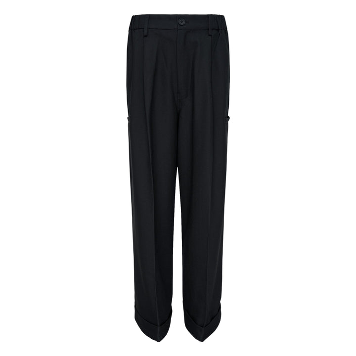 Melitta Baumeister Pointy Tailored Pants in black, featuring wide-leg silhouette, front pleats, thigh-level welt pocket, and sculptural pointed cuffed hem