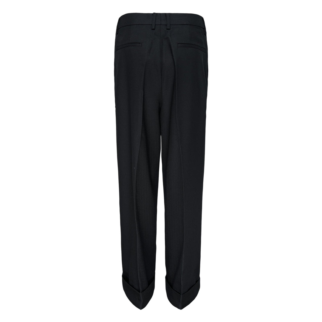 Melitta Baumeister Pointy Tailored Pants in black, featuring wide-leg silhouette, front pleats, thigh-level welt pocket, and sculptural pointed cuffed hem