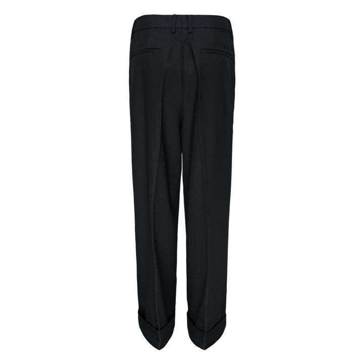 Melitta Baumeister Pointy Tailored Pants in black, featuring wide-leg silhouette, front pleats, thigh-level welt pocket, and sculptural pointed cuffed hem