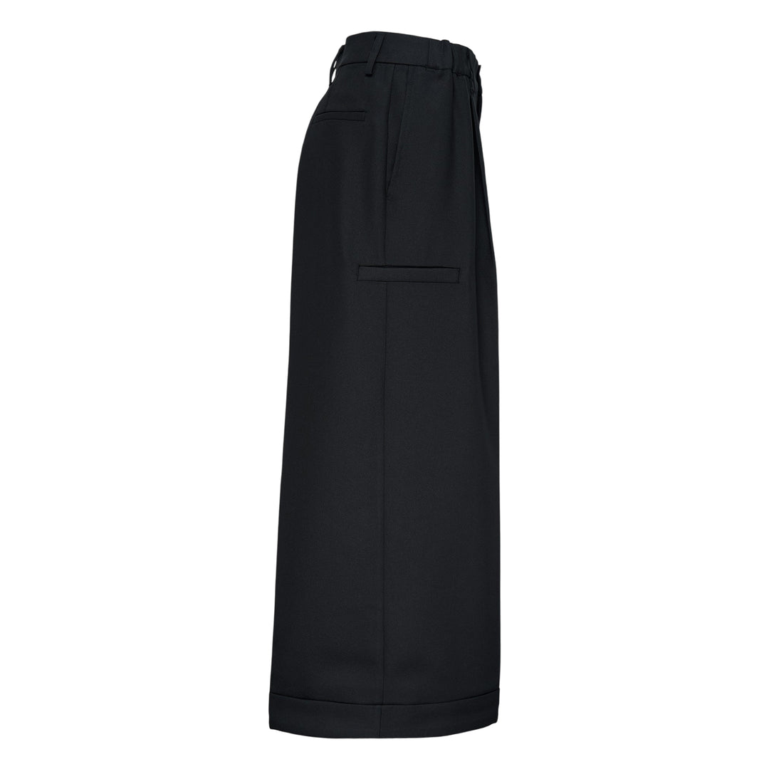 Melitta Baumeister Pointy Tailored Pants in black, featuring wide-leg silhouette, front pleats, thigh-level welt pocket, and sculptural pointed cuffed hem