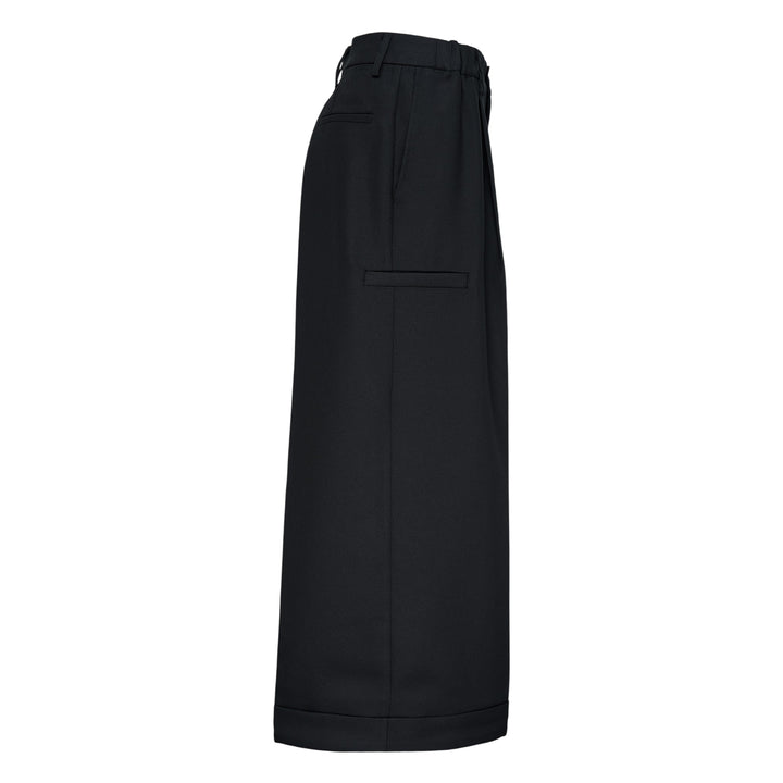 Melitta Baumeister Pointy Tailored Pants in black, featuring wide-leg silhouette, front pleats, thigh-level welt pocket, and sculptural pointed cuffed hem