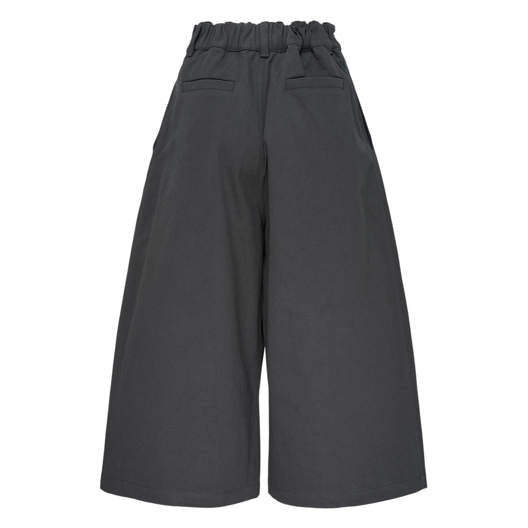 Melitta Baumeister charcoal wide-leg cargo culottes with high waist, sculptural rounded zip utility pocket, and A-line silhouette, shot flat on white background